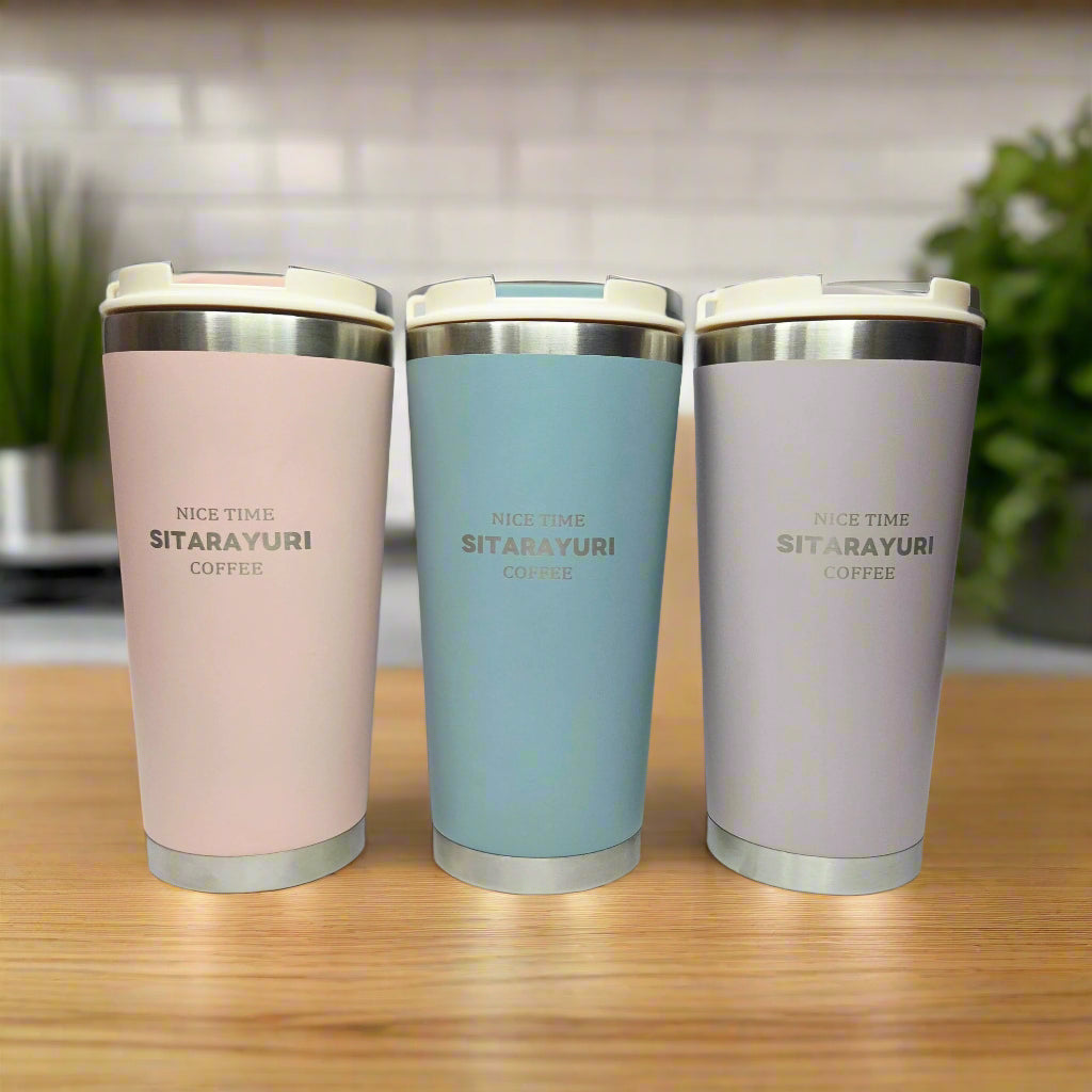 Three insulated coffee cups in gray, blue, and pink on a white background