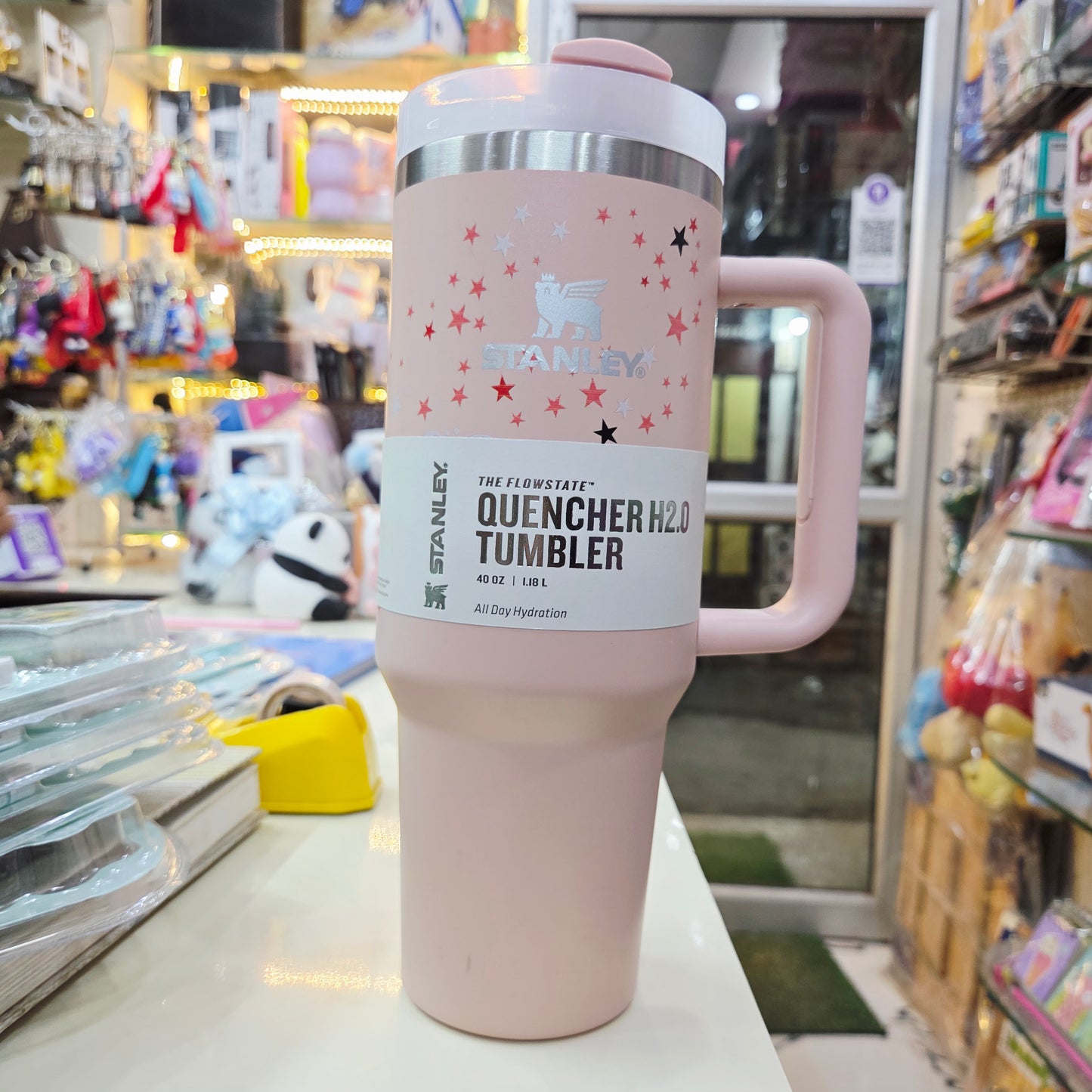 Pink tumbler with 'Stanley' branding in a store setting